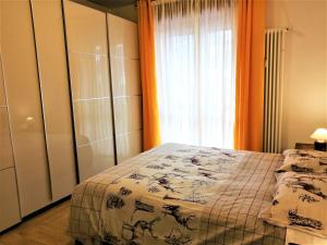 een slaapkamer met een bed en een groot raam bij Appartamento con 3 camere in centro Aosta CIR-AOSTA-0325 in Aosta