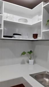 una cucina con armadi bianchi, lavandino e pianta di Casa Erelle -1 Bedroom guest house #2 ad Antipolo