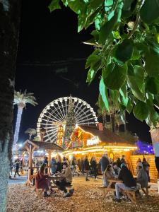 people sitting at tables in front of a christmas market at night at Alexandre in Nice