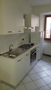 een witte keuken met een wastafel en een fornuis bij Appartamenti Sella&Mosso! Vespolina in Mosso Santa Maria