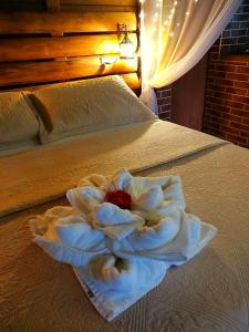 a white flower sitting on top of a bed at ॐ Rosa Astral ॐ in Praia do Rosa