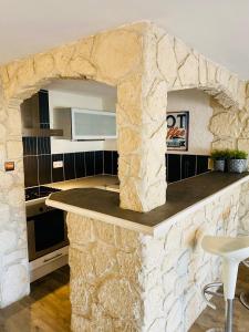 a kitchen with a stone wall with a counter at "Méditerranée" Salon vue mer au coeur de la ville 10m de la plage in Canet-en-Roussillon