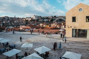 een groep mensen die buiten een gebouw met paraplu's staan bij Oporto Wine Cellars Flat With Terrace in Vila Nova de Gaia