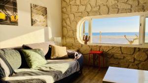 a living room with a couch and a window at "Méditerranée" Salon vue mer au coeur de la ville 10m de la plage in Canet-en-Roussillon