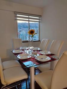 un tavolo con sedie e un vaso con un girasole sopra di Apartamento Céntrico, Privado, Iluminado, Soleado, Av Arce a La Paz