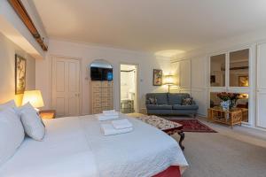 a bedroom with a large white bed and a living room at Attractive 2BR flat in Little Venice, Maida Vale in London