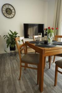 a dining room table and chairs with wine glasses on it at Apartament przy Plantach in Nowy Sącz