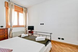 a bedroom with a bed with white sheets and a window at Cozy terrace apt close to Eataly and metro Piramide in Rome
