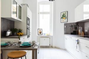 een keuken met witte kasten en een houten tafel bij 4-Zi Urban Design 120m² BRANDNEW 200Mbit in Berlijn