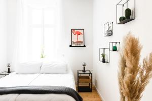 een witte slaapkamer met een bed en een aantal planten bij 4-Zi Urban Design 120m² BRANDNEW 200Mbit in Berlijn