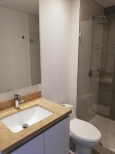 een badkamer met een wastafel, een toilet en een douche bij Acogedor Apartamento en Centro Internacional Bogotá in Bogota