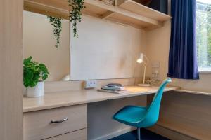 a room with a desk and a blue chair at For Students Only Private Bedrooms with Shared Kitchen at Shaftesbury Hall in the heart of Cheltenham in Cheltenham