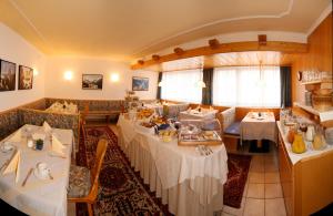 een eetkamer met tafels en stoelen in een restaurant bij Pension Tirol in Nauders