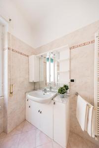 biała łazienka z umywalką i lustrem w obiekcie I Fiori 3-16 Apartment by Wonderful Italy w San Remo +11 zdjęć