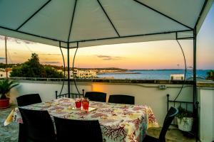a table on a balcony with a view of the ocean at Domusvacanza Salento in Santa Caterina di Nardò