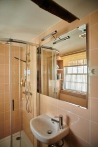 a bathroom with a sink and a shower with a mirror at Casa da Praça Velha Guest House in Braga +27 photos