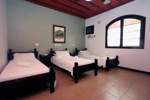 a room with two beds and a window at Giprita Wellness Hotel Ubatuba in Ubatuba