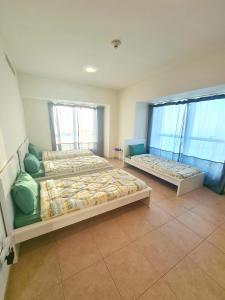 two beds in a room with two windows at AT THE TOP MARINA, Award winning property, Walk to Beach and Metro station, coliving in Dubai