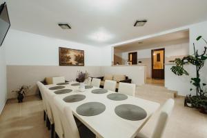 een witte eetkamer met een tafel en stoelen bij Pensiunea Alin in Turda