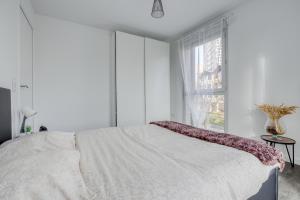 Un dormitorio blanco con una cama grande y una ventana en Superbe T2 COSY à 15mn de Paris, en Alfortville