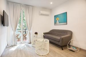 ein Wohnzimmer mit einem Sofa und 2 Tischen in der Unterkunft The White Flats Les Corts in Barcelona