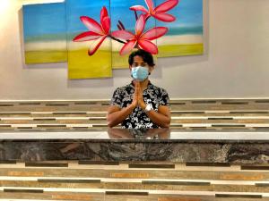 a woman wearing a mask while sitting at a table at Serenade Beach Hotel in Hikkaduwa
