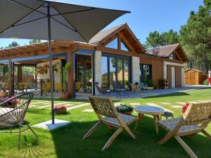 Un patio con sillas, una mesa y una sombrilla. en Glamping Illa de Arousa, en A Illa de Arousa