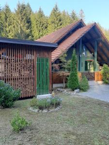 een huis met een groene deur in een tuin bij Bjelolasica “Cimbal” in Jasenak