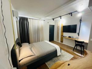 Dormitorio con cama, escritorio y TV en Ego HOME, en Cluj-Napoca