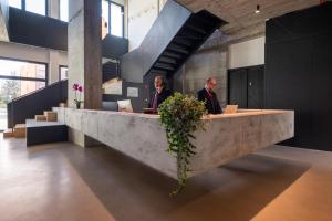 two men sitting at a reception desk in a building at Camplus San Pietro in Rome