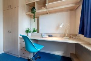 Habitación con escritorio y silla azul. en For Students Only Private Bedrooms with Shared Kitchen at Upper Quay House in the heart of Gloucester en Gloucester