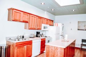 a kitchen with wooden cabinets and white appliances at Renovated building in the heart of Rapid City! in Rapid City