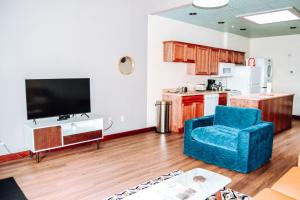 a living room with a blue chair and a television at Renovated building in the heart of Rapid City! in Rapid City
