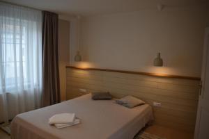 ein Schlafzimmer mit einem Bett mit zwei Handtüchern darauf in der Unterkunft FLH - Grandparent's House- A small beautiful house in Sibiu