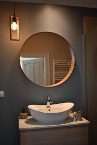 ein Badezimmer mit einem weißen Waschbecken und einem Spiegel in der Unterkunft FLH - Grandparent's House- A small beautiful house in Sibiu