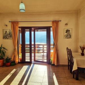 a dining room with a table and a glass door at Pensiunea La Bunica in Rugineşti