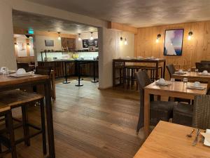 a restaurant with wooden floors and tables and chairs at Hôtel Neste de Jade in Saint-Lary-Soulan