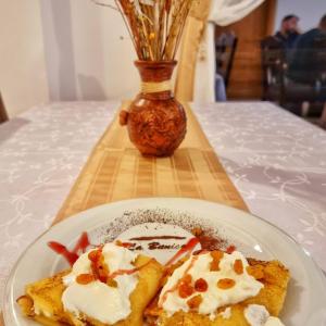 un plato con un trozo de comida en una mesa en Pensiunea La Bunica, en Rugineşti