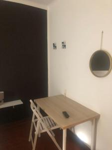 a wooden table and a chair in a room at MyRoom sui Portici in Bologna