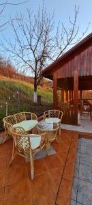 two wicker chairs and a table on a patio at Vila cu Ciubar & Jacuzzi - Sunset Hill House in Cuvin