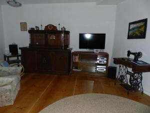 Una sala de estar con un televisor de pantalla plana y un sofá. en Ferienwohnung-Kutscherhaus, en Wernigerode