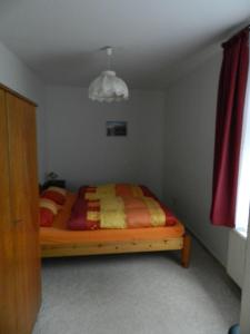 1 dormitorio con 1 cama con manta roja y amarilla en Ferienwohnung-Kutscherhaus en Wernigerode