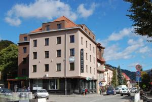 a building on the corner of a street with cars at Rakhiv Hotel & Apartments in Rakhiv