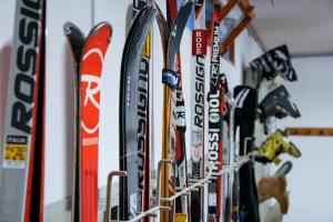 Un tas de skis sont suspendus sur un mur dans l'établissement Meublè Sci Sport, à Bormio
