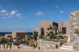 a rendering of the exterior of a resort with palm trees at Acro Suites - A Wellbeing Resort in Agia Pelagia