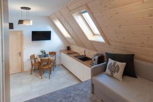 a kitchen and a living room with a couch and a table at Apartamenty - Droga do Walczaków 37a in Zakopane