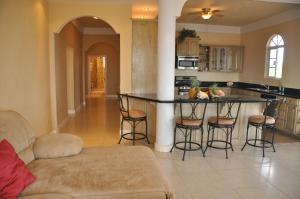 a kitchen with a bar with stools in a room at Sea View Suites in Placencia Village