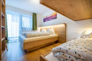 a bedroom with two beds and a large window at WiWa Appartement in Flachau