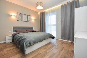 a bedroom with a bed and a window at Schneidemühl Premium Apartments in Piła