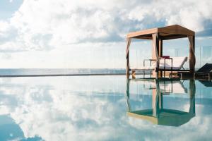 a swimming pool with two chairs on the edge of the water at Grand Hyatt Playa del Carmen Resort in Playa del Carmen